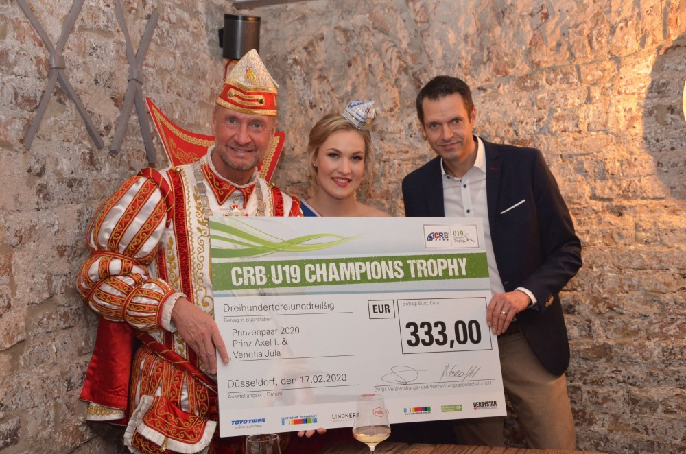 Martin Meyer (rechts) überreicht dem Prinzenpaar einen Scheck für den guten Zweck. (Foto: CRB U19 Champions Trophy/Piet Keusen)